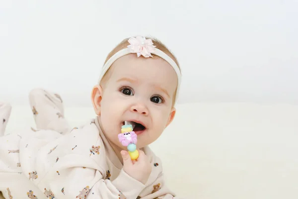 O bebê mente e mastiga um brinquedo para dentição. — Fotografia de Stock