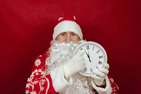Санта тримає білий годинник, який говорить, що за дві хвилини до дванадцятої. закрийся — стокове фото