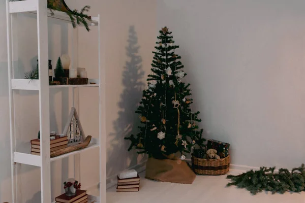 Christmas candles are lit on the shelves next to decorative Christmas trees and books. — Stock Photo, Image