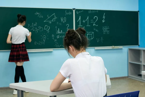 Asian high school girl solves geometry on the blackboard — Stock Fotó