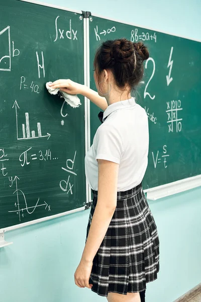 Asian high school girl solves geometry on the blackboard — Stock Fotó