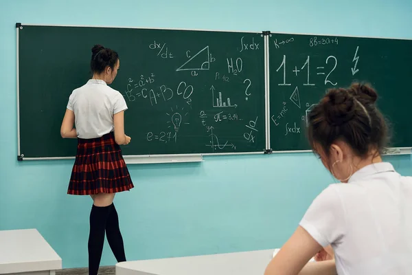 Asian high school girl solves geometry on the blackboard — Stock Fotó