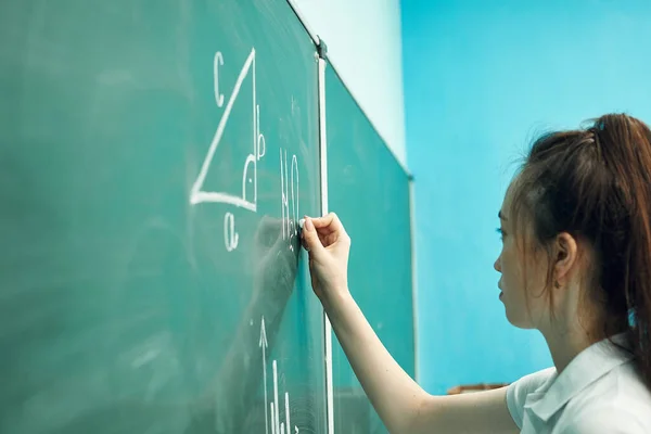 Aziatische middelbare school meisje lost geometrie op de schoolbord — Stockfoto
