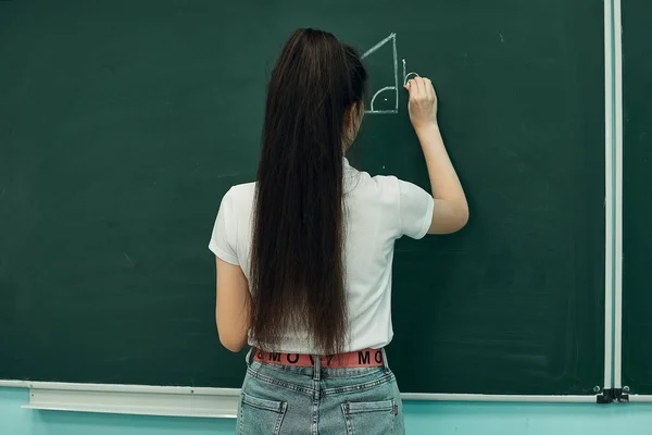 Asian high school girl solves geometry on the blackboard — Stock Fotó