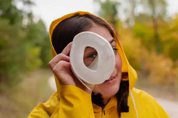 Veselá mladá žena ve žlutém plášti a žlutých botách pózuje pro fotoaparát. — Stock fotografie