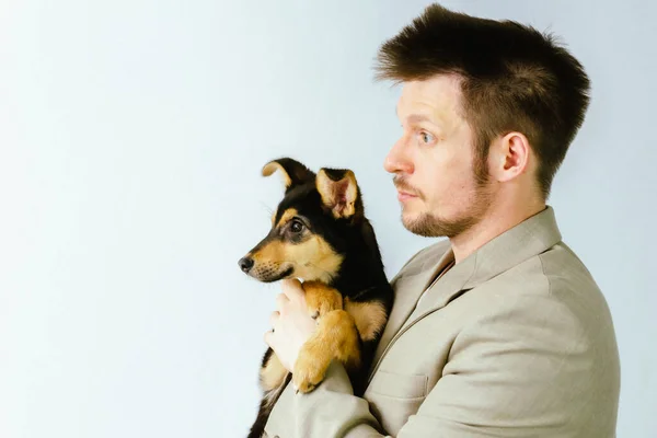 Erkek gönüllü köpek kulübesinde köpekle oynuyor..