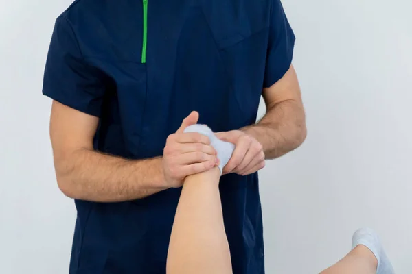 Médico ou Fisioterapeuta trabalhando examinando o tratamento da perna lesionada do atleta paciente masculino, fazendo a terapia de reabilitação dor na clínica. — Fotografia de Stock