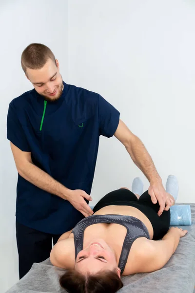 Sjukgymnast eller massageterapeut som arbetar med behandling av patientskador och som utför rehabiliteringsterapi på kliniken. Stockfoto