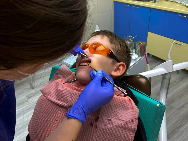 Jonge patiënt bij de tandarts. tandheelkundige behandeling. — Stockfoto