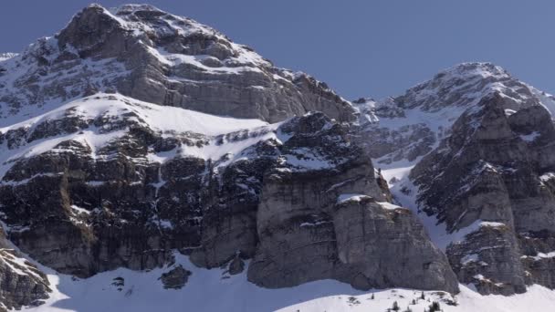 Sntis Schwgalp交换台 摄像机从巨大的岩石地块向左移动到Sntis发射塔 冬季积雪覆盖的高山 阳光普照的蓝天 旅游胜地 — 图库视频影像