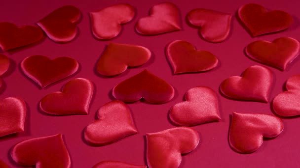 Valentijnsdag rode achtergrond. Rode valentijnskaarten en hartjes vliegen op het rode oppervlak en laten vrije ruimte voor tekst. — Stockvideo