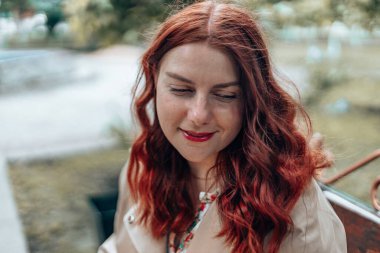 Güneşli bir sonbahar gününde gülen mutlu ve kendinden emin güzel bir kadın.