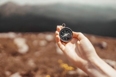 Gezgin el, güneşin altındaki güzel Karpatya dağlarında bir pusula tutuyor. Yatay afiş, mesaj için yer var. Tatil ve seyahat.