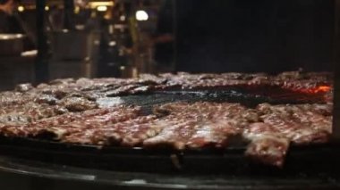 Büyük daireli bir restoranda yanan ızgarada Amerikan yemeği lezzetli bbq pirzolası. Sokak yemekleri festivali.