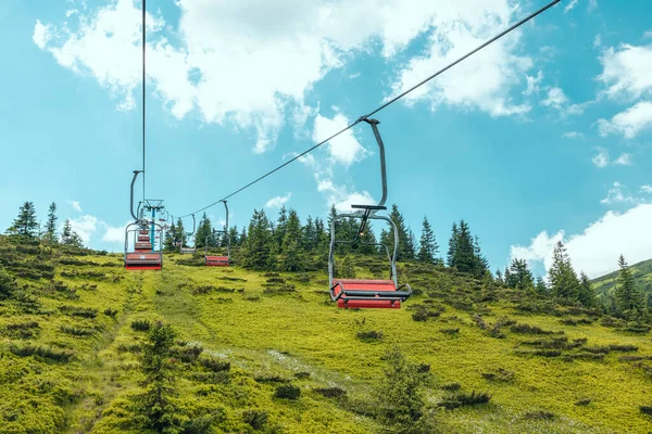 Panorama pohled na lanovku proti zatažené modré obloze. Vysoká hora v bílém mraku. Pěší turistika. Dobrodružná turistika. — Stock fotografie