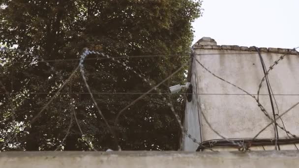 Telecamera di sicurezza dell'edificio. Muro di cemento con filo spinato contro i migranti. Concetto carcerario, salvataggio, rifugiato. Linea di pericolo — Video Stock