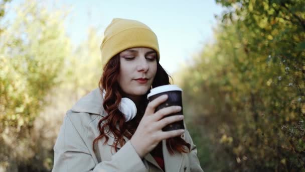 Joven mujer feliz bebiendo café caminando afuera en la calle — Vídeos de Stock