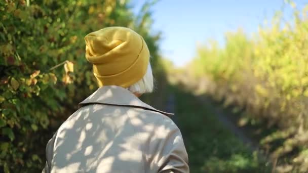 Közelkép portré idősebb nő elegáns ruhák séta gyönyörű színes őszi városi park. — Stock videók