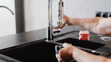 Mutfakta bulaşık yıkayan kadınların ellerini kapat.