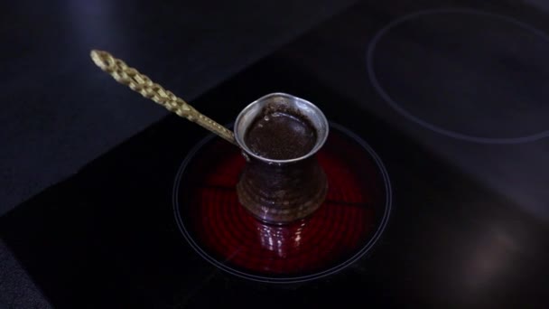 Török kávét főzök réz jezve-ben elektromos tűzhely felett. Habok és buborékok a hagyományos edényben. Lusta reggel. — Stock videók