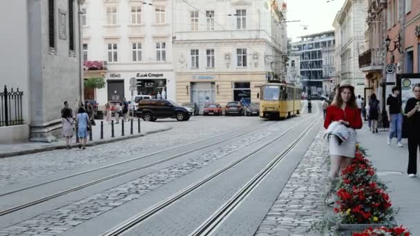 Lviv, Ukraina - 7 juli 2021: Gamla gula spårvagnsturer längs spåren i stadens centrum. Ekologiskt sätt För kollektivtrafik. — Stockvideo