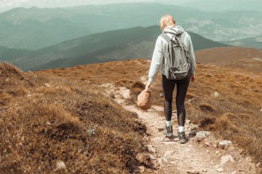 Dağın tepesinde yürüyüş yapan bir kadın. Macera tatili. Dağcılık sporu yaşam tarzı konsepti