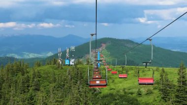 Carpathian Dağları manzarası ve Ukrayna 'daki güzel mavi gökyüzü arkaplanı için gökyüzüne karşı kablolu bir araba. Aerial Cableway popüler turizm merkezi