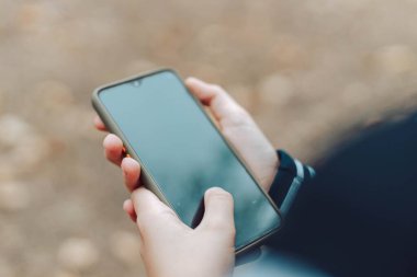 Çocuk elleri yaz parkında akıllı telefon kullanır, dışarıdaki aygıtlara bakar