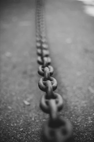 Black heavy metal chain on graphite asphalt background with copy space. Business strategy concept. Soft focus.