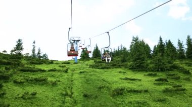 Karpatlar, Ukrayna - 11 Temmuz 2021: insanlar teleferiğe biniyor. Karpatlar 'ın parlak doğa manzarası ve Ukrayna' nın güzel mavi arkaplanı. Kablolu araba gökyüzüne karşı