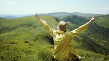 Çekici, neşeli bayan yürüyüşçü, saçları rüzgarda uçuşan, dağın tepesinden hoş bir manzara. Güneşli yaz gününde Dağ Vadisi 'ne bakan bir kadın.