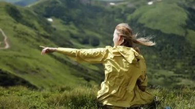 Çekici, neşeli bayan yürüyüşçü, saçları rüzgarda uçuşan, dağın tepesinden hoş bir manzara. Güneşli yaz gününde Dağ Vadisi 'ne bakan bir kadın.