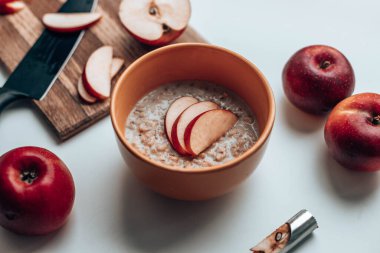 Masanın üzerinde elma parçaları olan lezzetli yulaf ezmesi. Üst Manzara. Sağlıklı diyet kahvaltısı