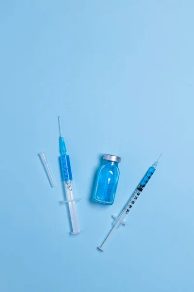 Engångssprutor Med Nålar Och Injektionsflaska Med Ljusblå Bakgrund Närbild Vaccination — Stockfoto