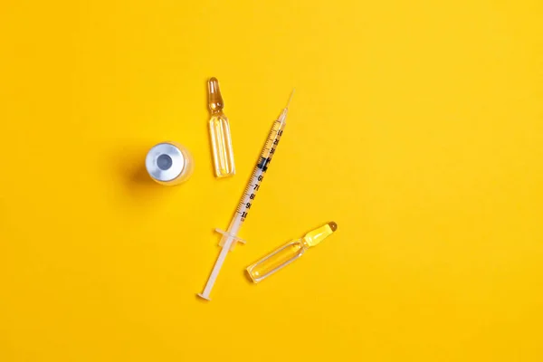 黄色のテーブルの背景にバイアルと注射器のクローズアップでワクチン 医学的概念 研究室 皮下注射予防接種 — ストック写真