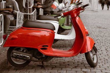 Eski şehir caddesinde park edilmiş iki kırmızı ve beyaz scooter. Her gün için şehir ulaşımı.