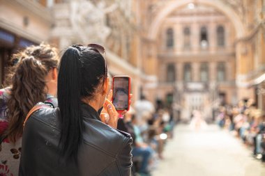 Odessa, Ukrayna, 19 Eylül 2021: Kadın akıllı telefon kullanarak fotoğraf çekiyor veya podyumda mankenlerin videosunu çekiyor