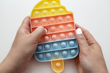 Çocuğun eli, sarı arka planda oyuncak silikona basar.