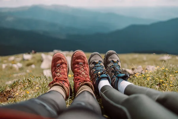 Couple of friends hiking foot hiker in front of a panoramic mountain, vacation concept