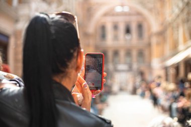 Odessa, Ukrayna, 19 Eylül 2021: Kadın akıllı telefon kullanarak fotoğraf çekiyor ya da şehirdeki bir podyumda manken videosu çekiyor