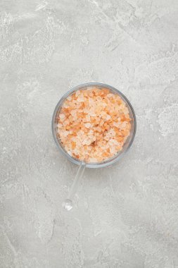 Himalaya pembe kristal tuzu gri beton arka planda cam bir kasede. Doğal sağlıklı organik yiyecekler..