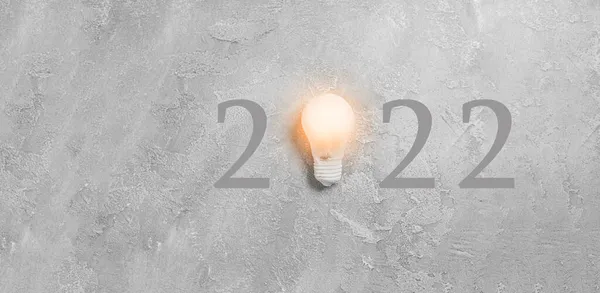 Neujahrsidee 2022 Mit Glühbirne Auf Grauem Betonhintergrund Flache Lage Draufsicht — Stockfoto