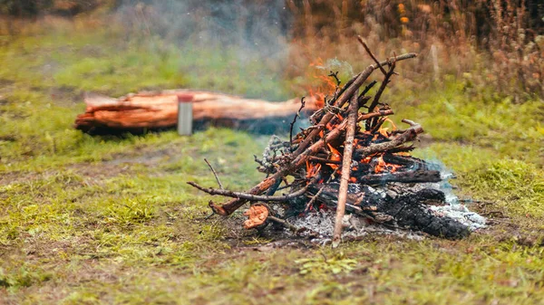 Dangerous bonfire flame in nature. Bonfire in the autumn forest. Trekking, adventure and seasonal vacation concept — Stock Photo, Image