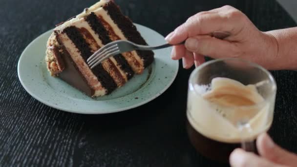 女人在咖啡店的木桌上用咖啡杯叉子切巧克力蛋糕 — 图库视频影像