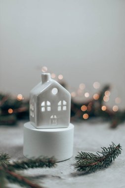 Gri arka planda beyaz, rahat ev modeli. Xmas ve Yeni Yıl teması. Noel ve Yeni Yıl tatili geçmişi. Evergreen Spruce, gri beton arka planda yer alan dallar.