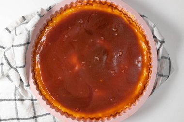 Beyaz arka planda beyaz tabakta karamel soslu klasik peynirli kek. Metin için alanı kopyala.