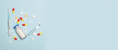 İlaç hapları ve sirynge mavi arka planda tıbbi bir sağlık hizmeti olarak.