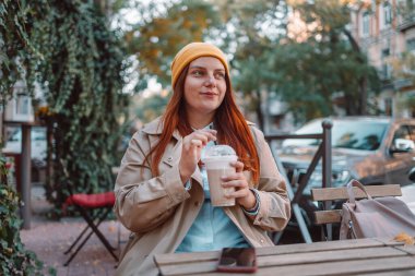 Cafe 'de kapuçino ya da latte içen güzel genç bir kadın.