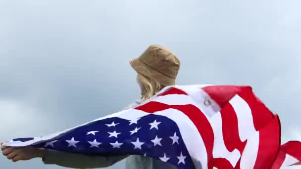 Victoria. La joven patriótica feliz ha levantado una bandera americana en sus manos. Viajes femeninos disfrutando de la vista senderismo aventura vacaciones al aire libre estilo de vida activo — Vídeo de stock