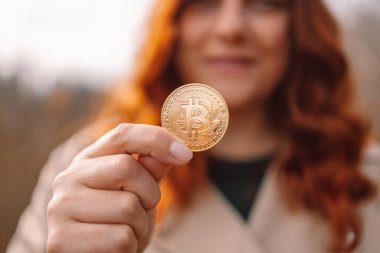 Altın Bitcoin bir iş kadınının açık havada elinde. Kripto para birimi kavramı